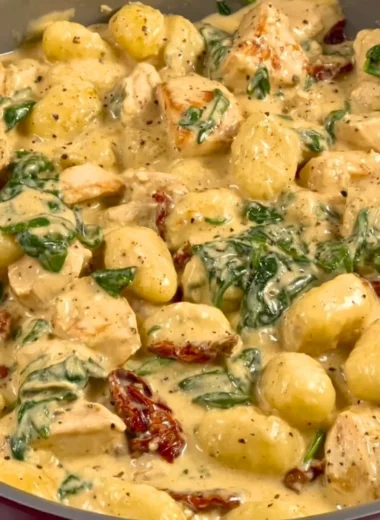 Bowl of creamy chicken gnocchi with herbs and vegetables