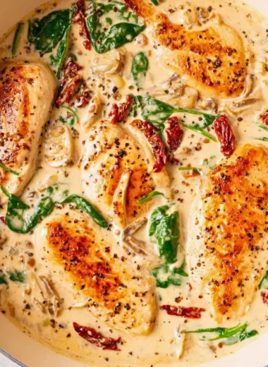 Creamy Tuscan chicken dish with herbs and colorful vegetables