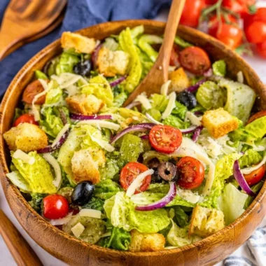 A colorful and fresh simple Italian salad with tomatoes, lettuce, and olives.