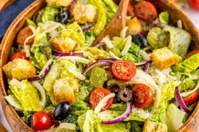 A colorful and fresh simple Italian salad with tomatoes, lettuce, and olives.