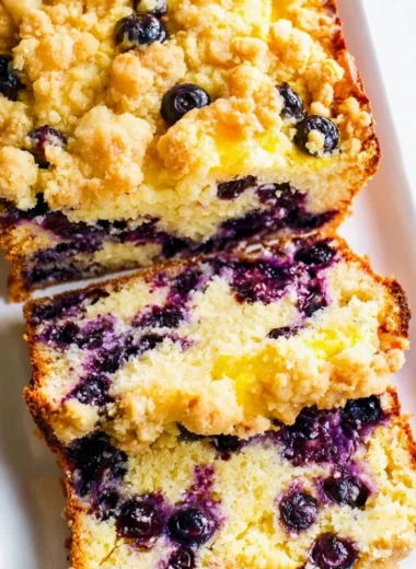 Homemade blueberry and lemon loaf garnished with fresh berries.