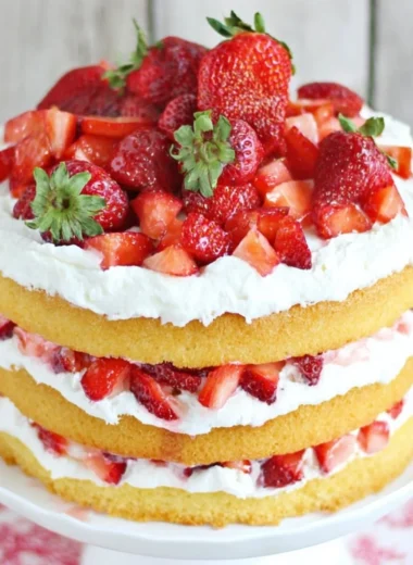 Delicious strawberry shortcake cake topped with fresh strawberries and whipped cream