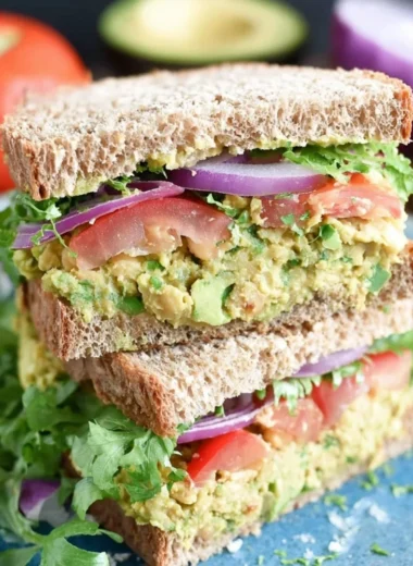 Chickpea avocado sandwich with fresh ingredients on a cutting board
