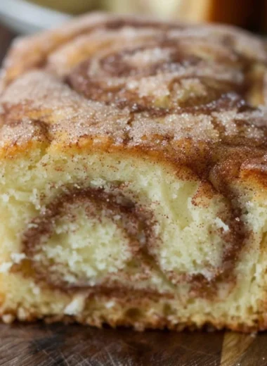 Freshly baked Cinnamon Swirl Donut Bread with a golden, cinnamon-sugar topping