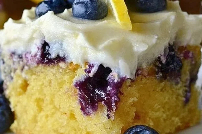 Cozy lemon blueberry poke cake topped with fresh blueberries and lemon glaze