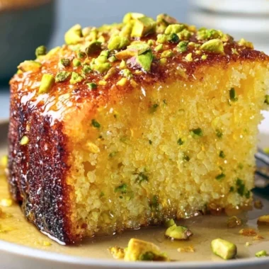 Cozy lemon pistachio cake topped with vibrant lemon zest and crushed pistachios