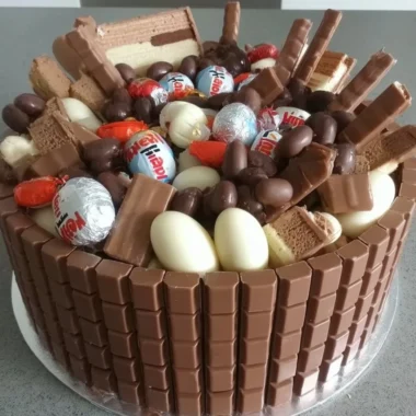 Decadent creamy Kinder Chocolate Cake topped with chocolate shavings.