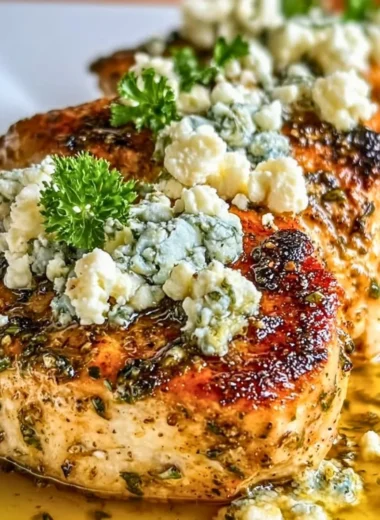 Plate of Greek chicken with lemon and feta served with herbs.
