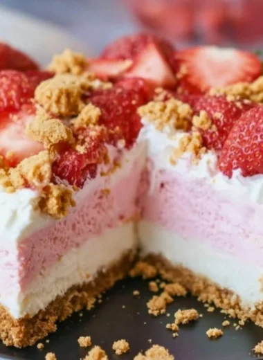 Delicious no-bake strawberry crunch cheesecake topped with fresh strawberries.