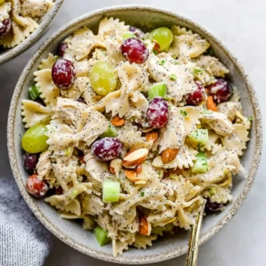 A vibrant bowl of Poppyseed Chicken Pasta Salad with colorful veggies.