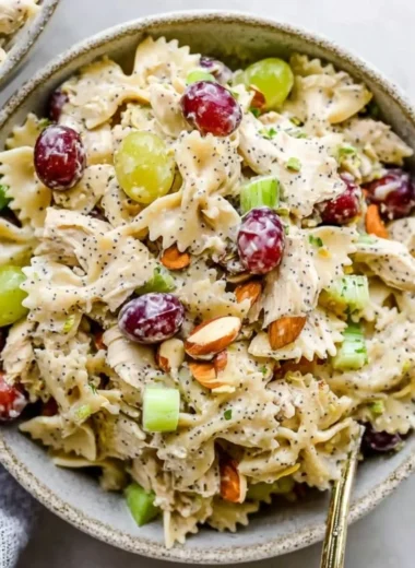 A vibrant bowl of Poppyseed Chicken Pasta Salad with colorful veggies.