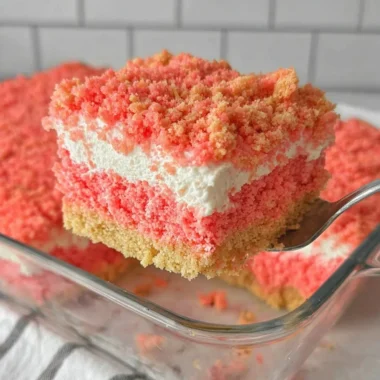 A delicious slice of Strawberry Crunch Cake topped with crunchy strawberry crumbles.