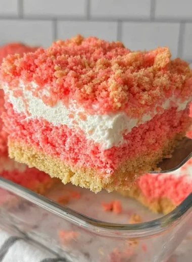 A delicious slice of Strawberry Crunch Cake topped with crunchy strawberry crumbles.