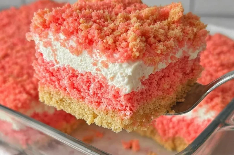 A delicious slice of Strawberry Crunch Cake topped with crunchy strawberry crumbles.