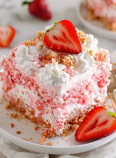 Slice of Strawberry Crunch Poke Cake with fresh strawberries and crunchy topping