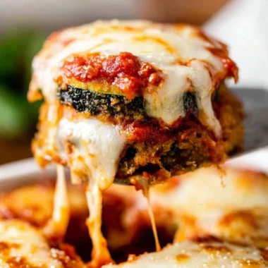 Baked Zucchini Parmesan with melted cheese and herbs