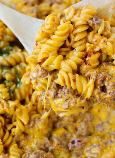 Creamy beef rotini pasta dish served in a bowl garnished with herbs