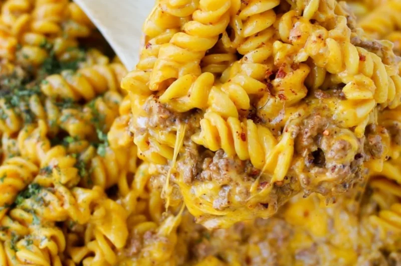 Creamy beef rotini pasta dish served in a bowl garnished with herbs