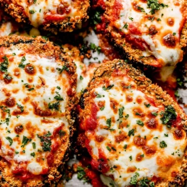 Crispy Baked Eggplant Parmesan topped with cheese and fresh basil