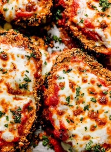 Crispy Baked Eggplant Parmesan topped with cheese and fresh basil
