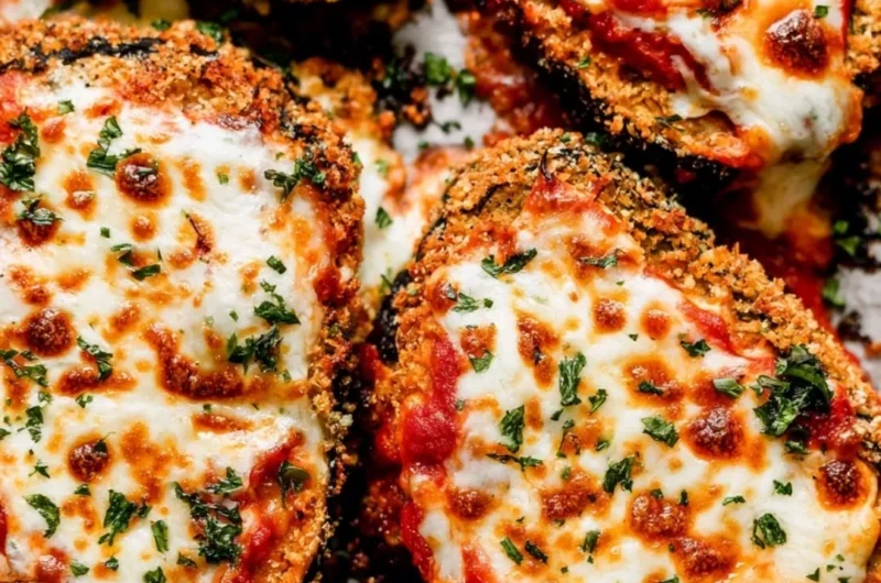 Crispy Baked Eggplant Parmesan topped with cheese and fresh basil
