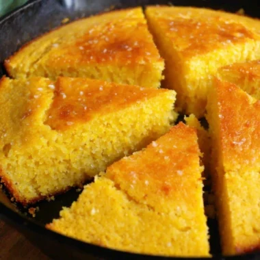 Slice of old-fashioned cornbread served on a plate with butter melting on top