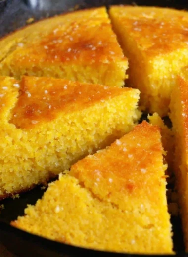Slice of old-fashioned cornbread served on a plate with butter melting on top
