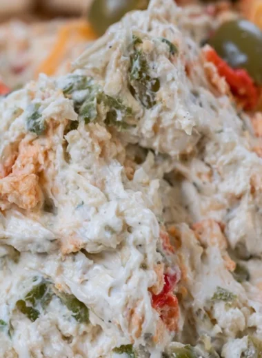 Delicious olive dip served in a bowl with crackers and vegetables