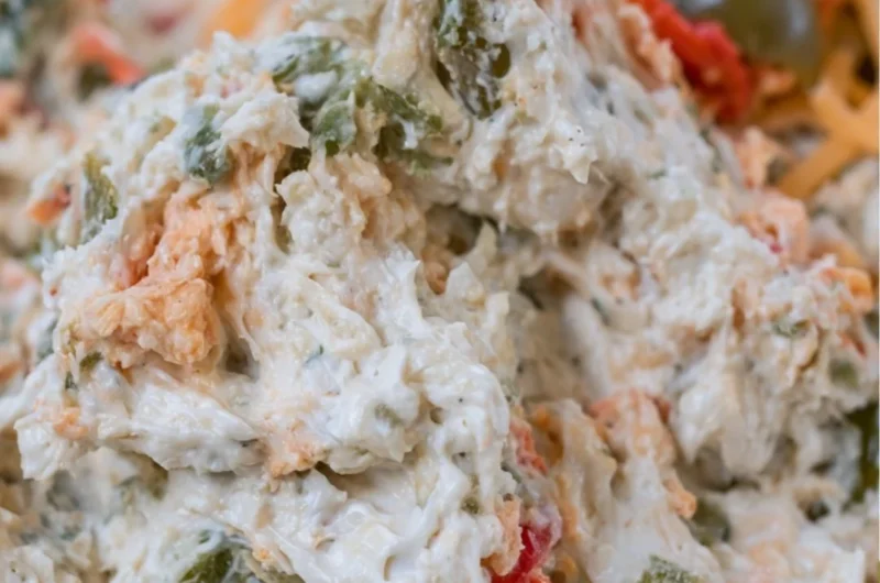 Delicious olive dip served in a bowl with crackers and vegetables