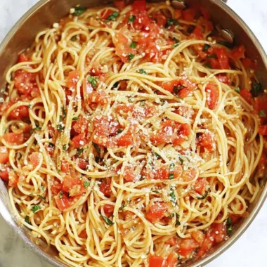 A colorful bowl of one-pot pasta with fresh vegetables and herbs.