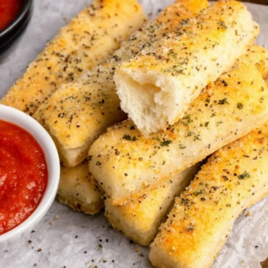 Freshly baked sheet pan breadsticks on a cooling rack