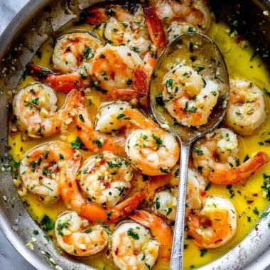 Plate of shrimp scampi with garlic, butter, and parsley garnish.