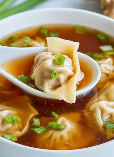 Delicious bowl of wonton soup with fresh herbs and dumplings