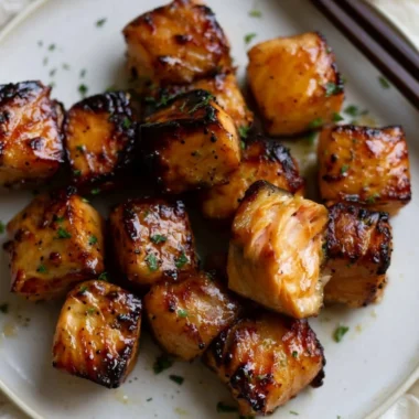 Air Fryer honey garlic salmon bites served on a plate with herbs