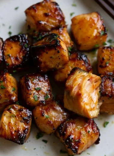 Air Fryer honey garlic salmon bites served on a plate with herbs