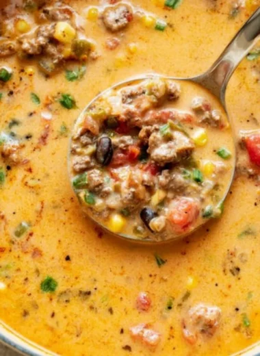 Bowl of warm and creamy taco soup garnished with fresh herbs and toppings