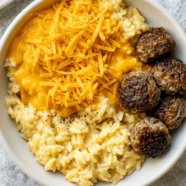 Creamy cheesy orzo pasta dish garnished with herbs and cheese
