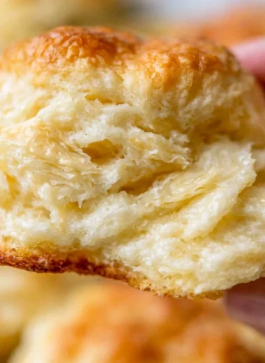 Fluffy homemade biscuits fresh out of the oven on a wooden table