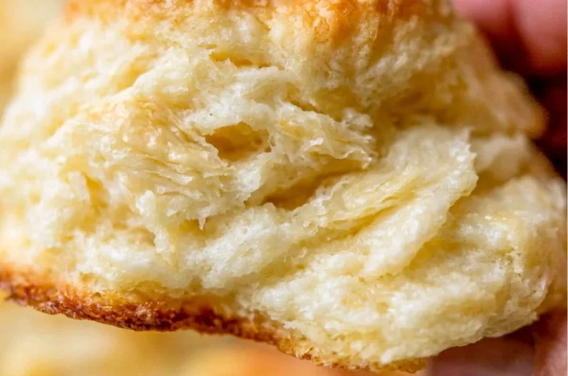 Fluffy homemade biscuits fresh out of the oven on a wooden table