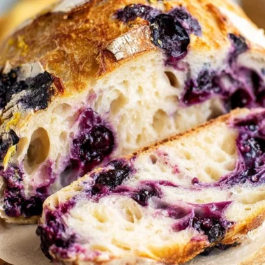 Sliced lemon blueberry sourdough bread on a wooden board