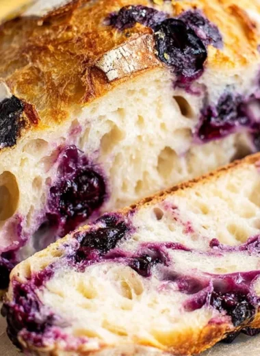 Sliced lemon blueberry sourdough bread on a wooden board