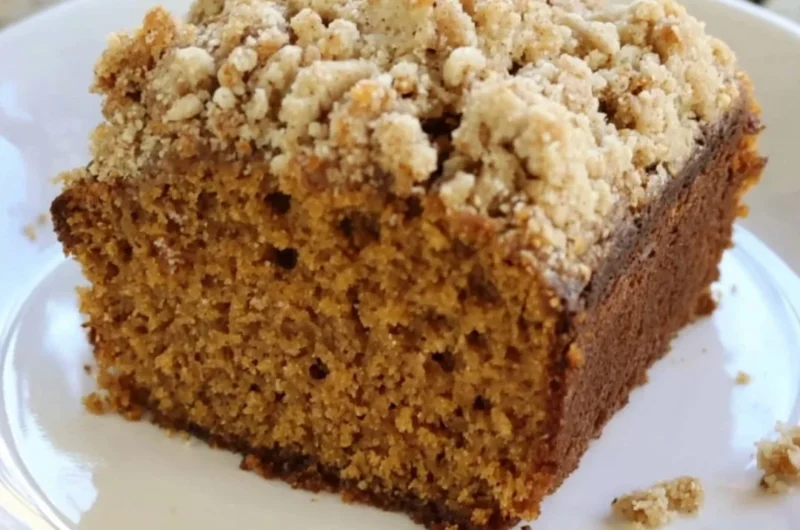 Slice of gingerbread coffee cake with crumble topping on a plate